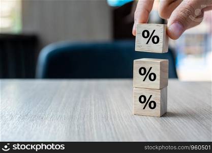 business man Hand putting wood cube block with percentage symbol icon. Interest rate, financial, ranking and mortgage rates concept