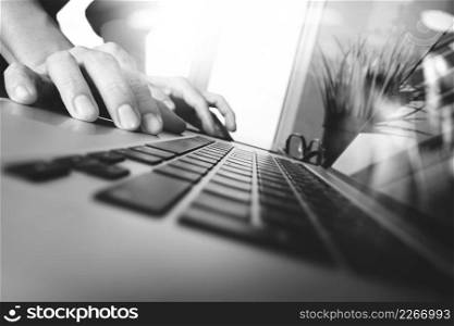 business man hand working on blank screen laptop computer on wooden desk as concept,black and white
