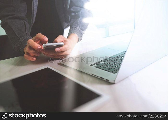 business man hand working on computer laptop computer and digital tablet and smart phone on marble desk, sun flare effect