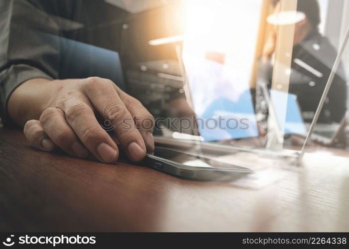 business man hand working on digital tablet computer and smart phone with digital layer business strategy and social media diagram on wooden desk