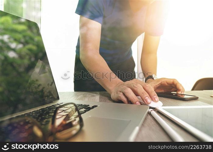 business man hand working on laptop computer on wooden desk as concept