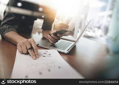 business man hand working on laptop computer with digital layer business graph information diagram on wooden desk as concept