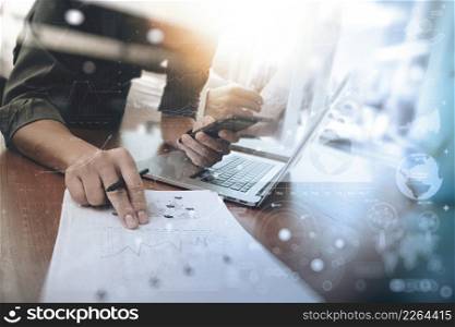 business man hand working on laptop computer with digital layer business graph information diagram on wooden desk as concept