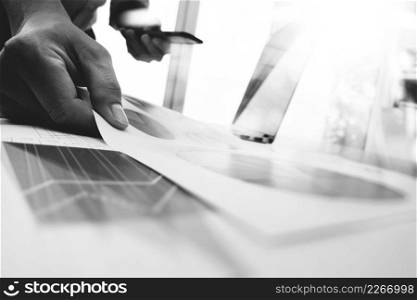 business man hand working on laptop computer with digital layer business graph information diagram on wooden desk as concept,black and white  