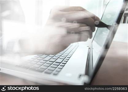 business man hand working with laptop computer and touching on screen on wooden desk as concept