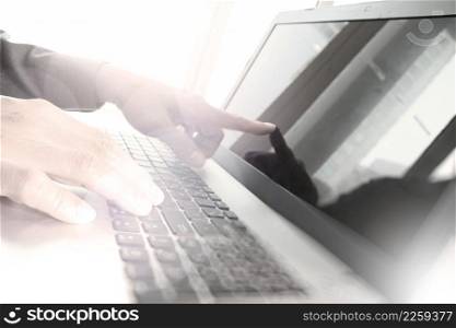 business man hand working with laptop computer and touching on screen on wooden desk as concept