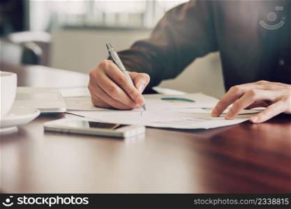 business man hand writing note paper on wooden table