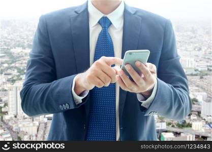 Business man hands using smart phone over blur city view background, businessman on phone