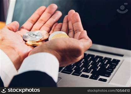 Business man holding crypto bitcoin currency money on hands with laptop computer, finance concept