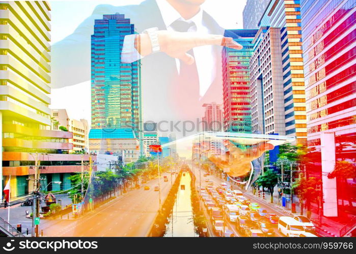 business man holding laptop with colorful cityscape. business concept.