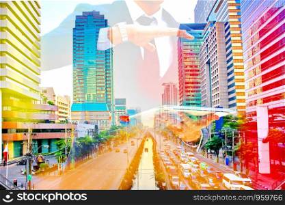 business man holding laptop with colorful cityscape. business concept.