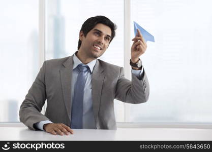 Business man holding paper airplane