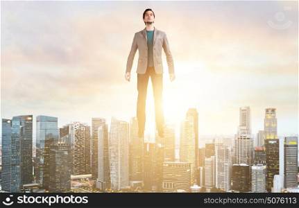 Business man hover over city skyline. Businessman hovering over down town on sunset.