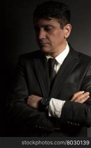 Business man in black suit with tie on a black background