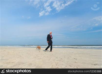 Business man in formal suit walking his dog at the beach