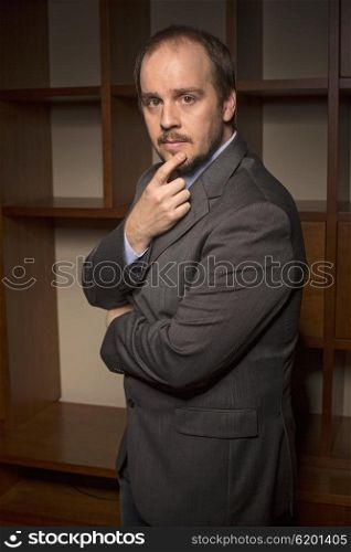 business man in home office with thoughtful look