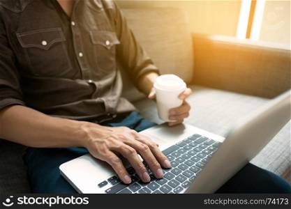 Business man in relax casual form working with laptop sitting on sofa at office