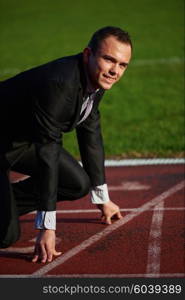 business man in start position ready to run and sprint on athletics racing track