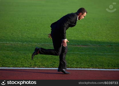 business man in start position ready to run and sprint on athletics racing track