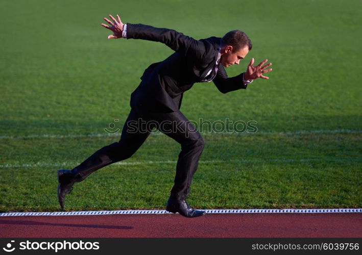 business man in start position ready to run and sprint on athletics racing track