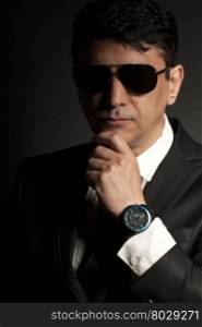 Business man in suit with sunglasses on a black background