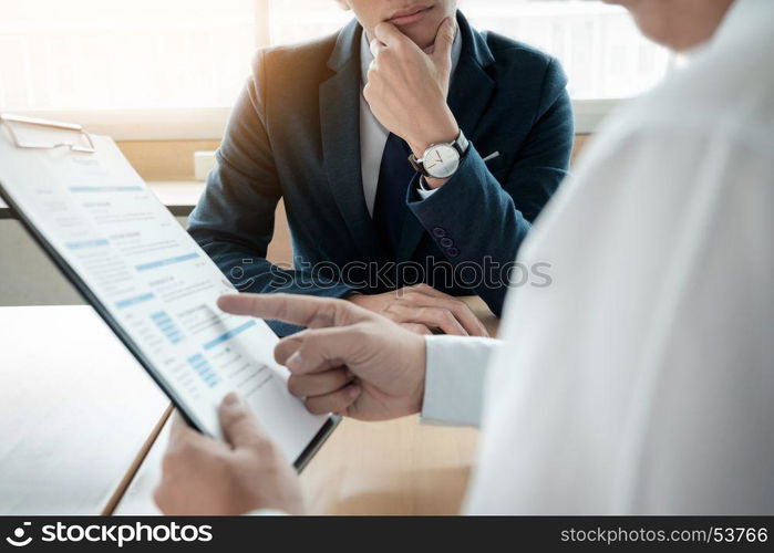 business man interviewer looking skeptical while listening to an asian female interview