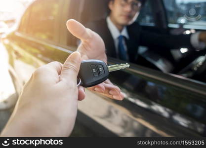 Business man is holding key car in the car