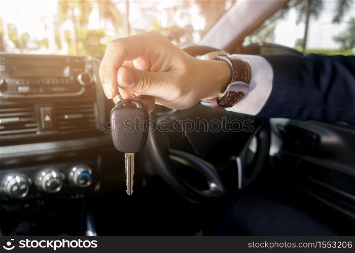 Business man is holding key car in the car