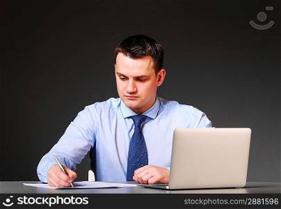 business man is sitting at his table with laptop
