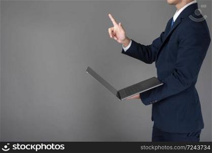 Business man is using laptop ,grey background in studio