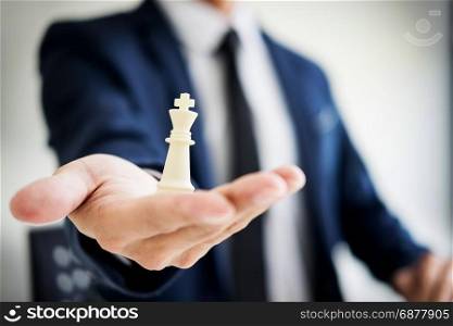 business man leader of a successful business holding the chess in hand Digital composite of Chess pieces