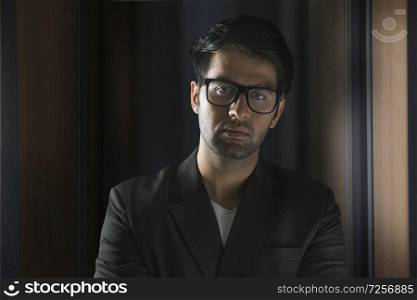 Business man looking at camera in office wearing eyeglasses