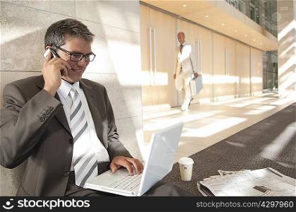 Business man on laptop and phone