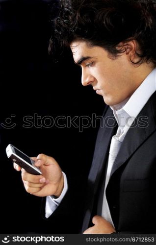 Business man on the phone sending a text message over a black background