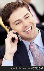 Business man on the phone smiling at his office