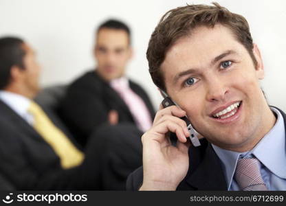 Business man on the phone smiling at his office