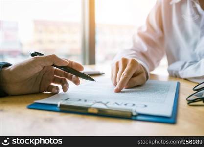 Business man pointing on contract paper to customer reading contract.
