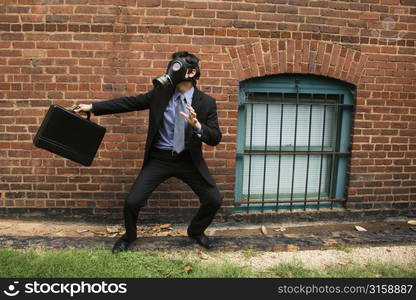 Business man posing, wearing a gas mask and holding a briefcase