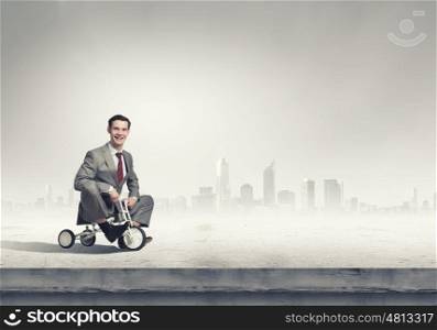 Business man riding bike. Young handsome businessman riding three wheeled bicycle