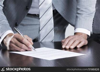 Business man sign contract. Business man sign contract standing near the table