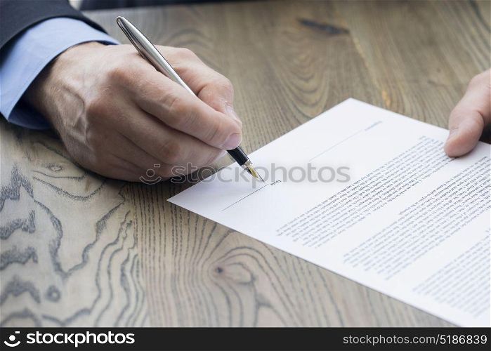 Business man signing a contract. Business man signing a contract with shallow focus on pen and date