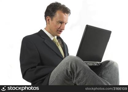 Business man sitting in a relaxed position with his laptop on his knees