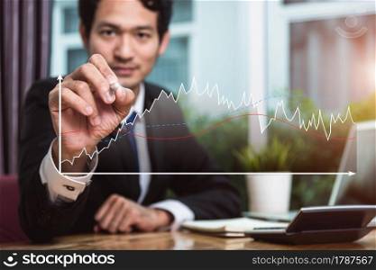 Business man sitting on desk writing growth chart graph finance at him office