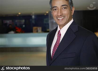 Business man standing in hotel lobby, portrait