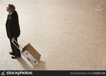 Business man standing with suitcase in lobby