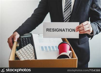 Business man stressing with resignation letter for quit a job packing the box and leaving the office , Resignation concept