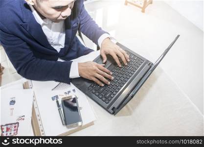 business man typing on laptop computer in office
