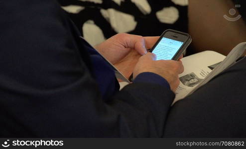 Business man uses his phone checking his e-mail