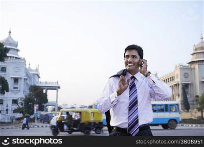 Business man using cell phone, smiling