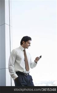 Business man using cell phone, smiling